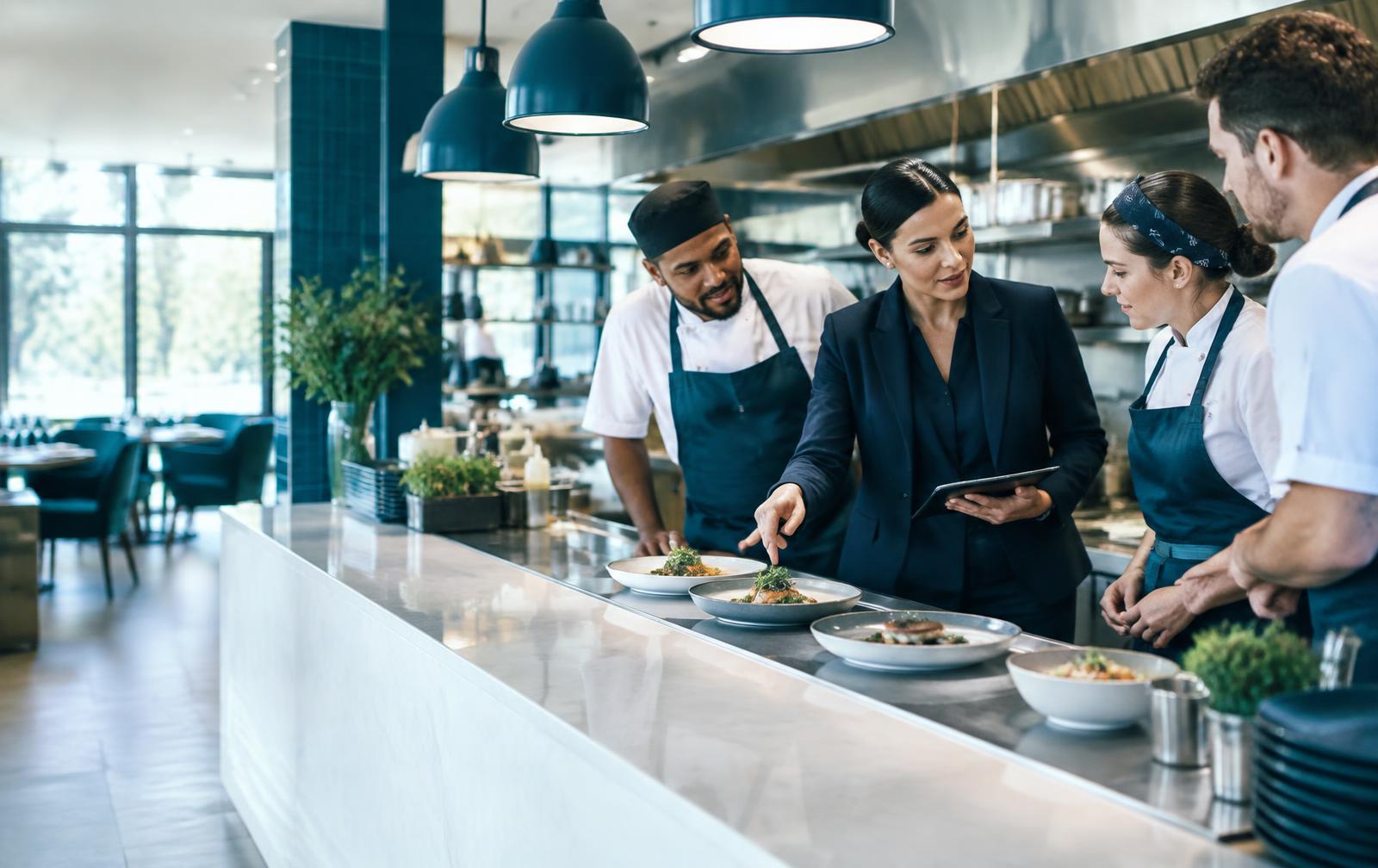Restaurant manager reviewing service with the kitchen team